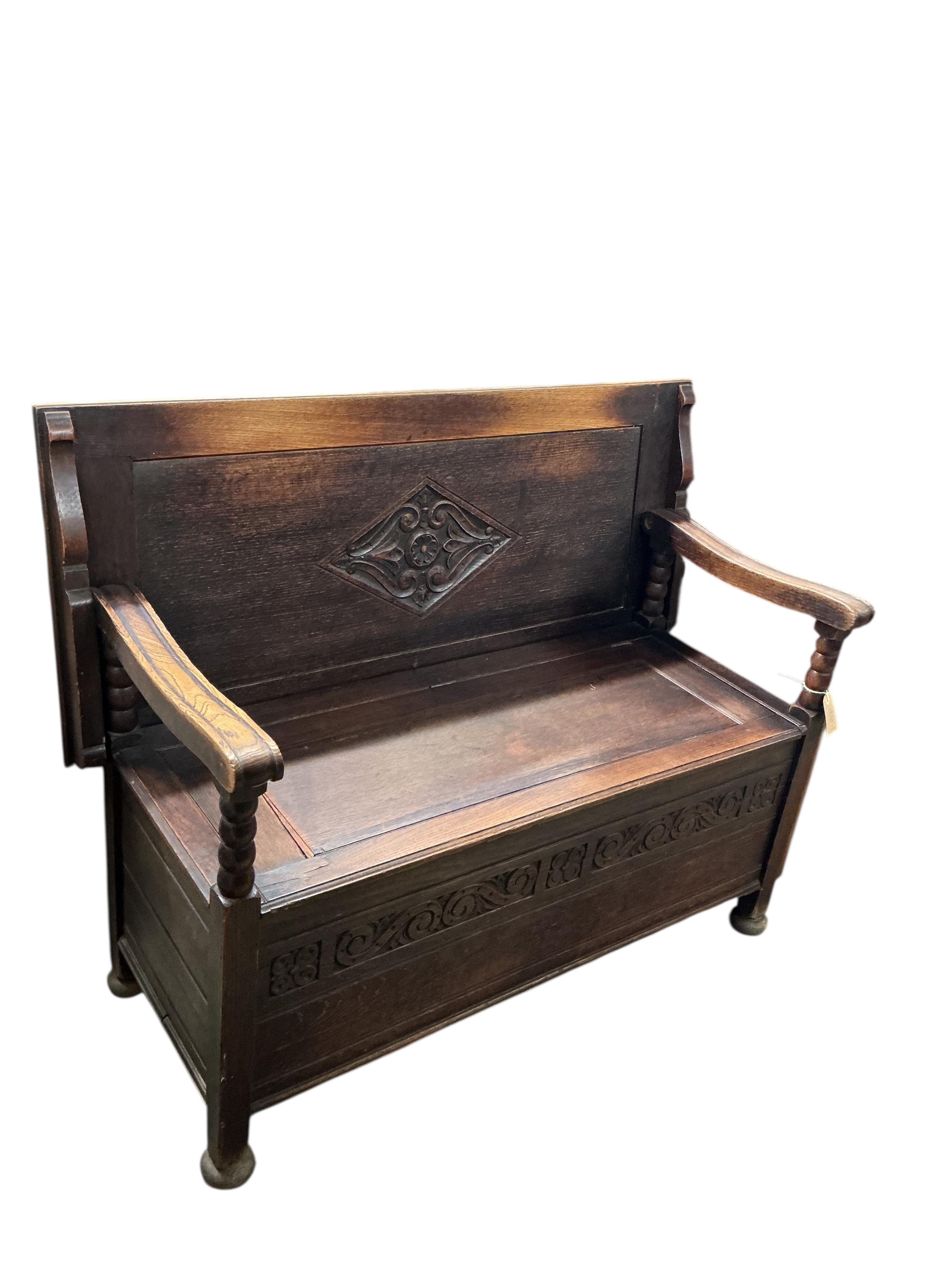 An early 20th century carved oak monks bench, width 116cm, depth 49cm, height 70cm